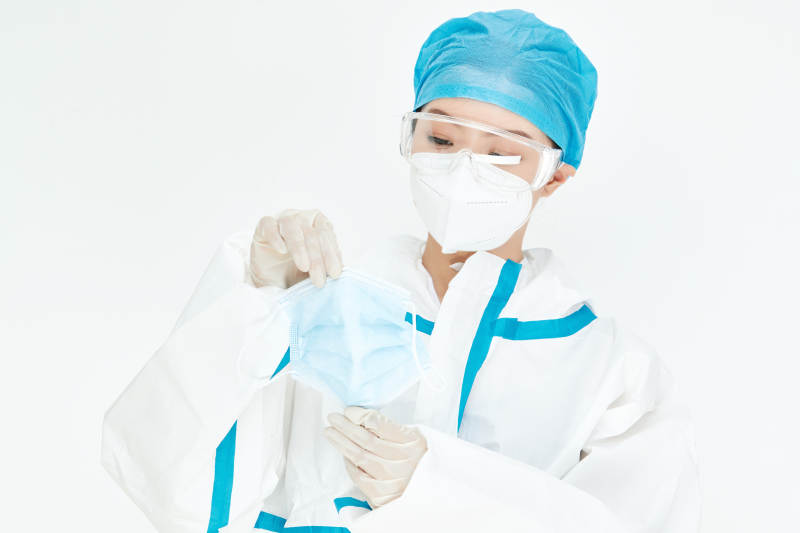 穿白色防护服佩戴护目镜口罩的女性医疗人员图片