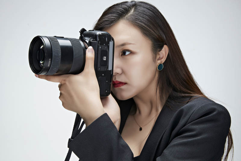 棚拍白色背景亚洲青年女性摄影师图片