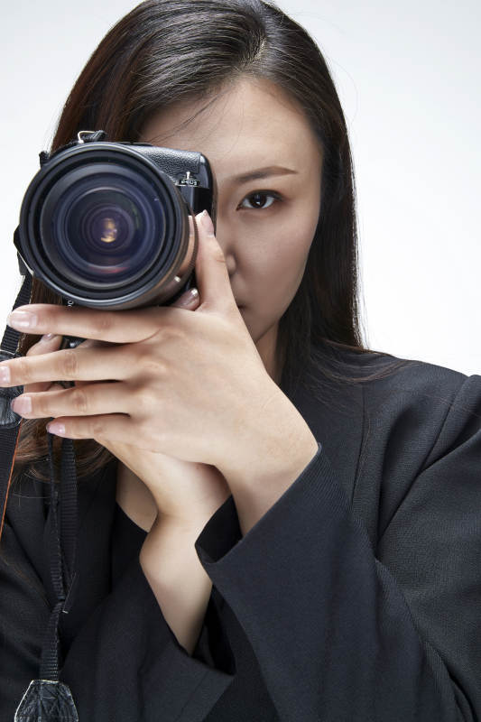 棚拍白色背景亚洲青年女性摄影师图片