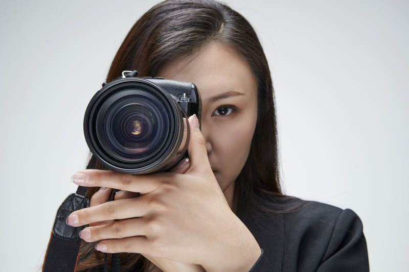 棚拍白色背景亚洲青年女性摄影师图片