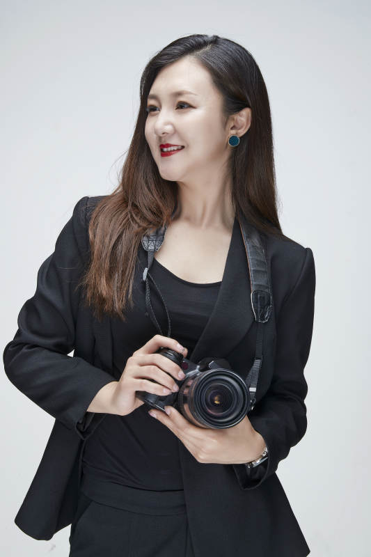 棚拍白色背景亚洲青年女性摄影师图片