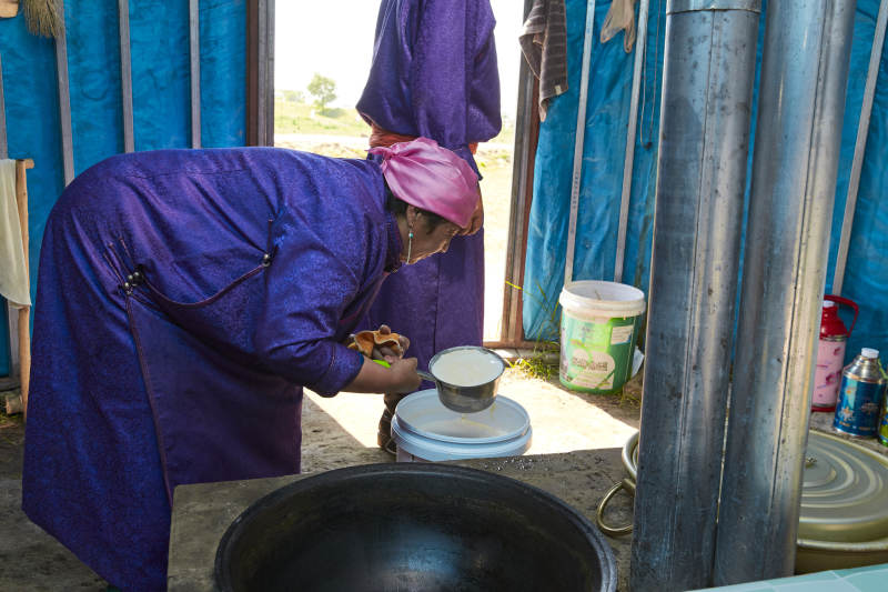 在蒙古包内用传统工艺熬煮制作奶豆腐过程图片