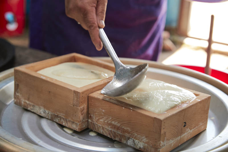 在蒙古包内用传统工艺熬煮制作奶豆腐过程图片