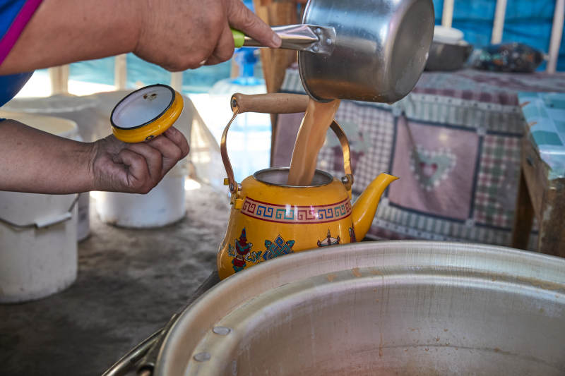 在蒙古包内用传统工艺熬煮蒙族奶茶的过程图片