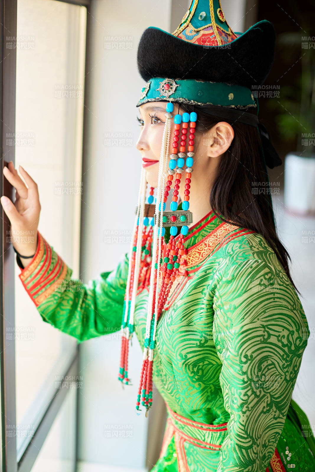 室内穿着绿色蒙古袍的蒙古族年轻女性图片