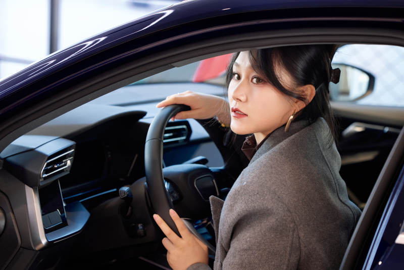在汽车4S店试驾车辆的亚洲美女图片