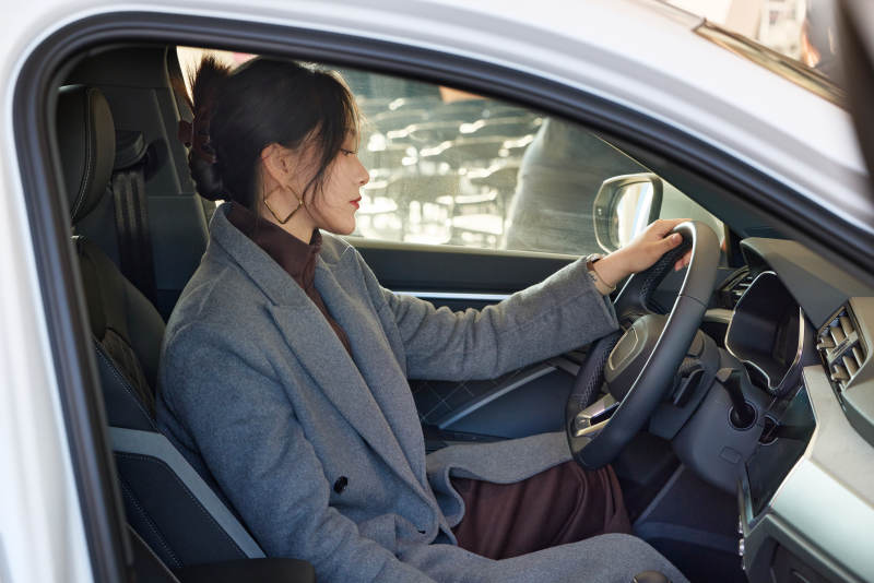 在汽车4S店试驾车辆的亚洲美女图片