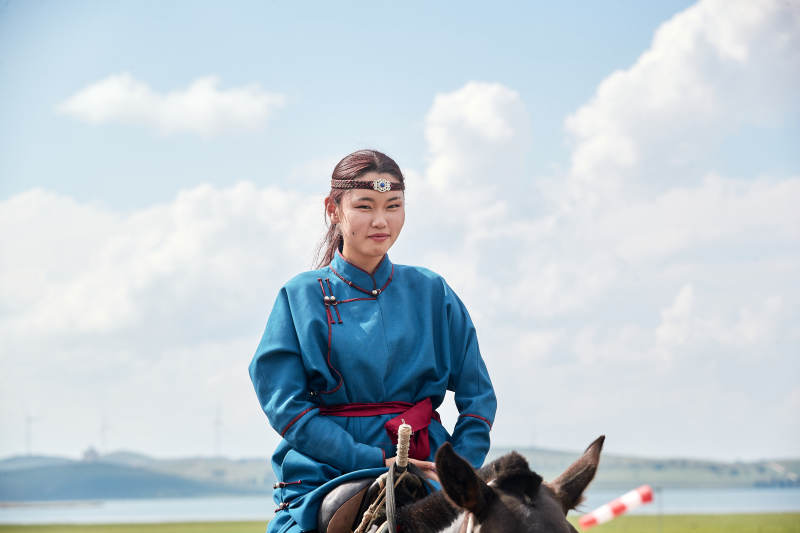 草原那达慕大会上骑着马的蒙古姑娘图片