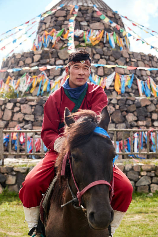 草原那达慕大会上骑着马的蒙古人图片