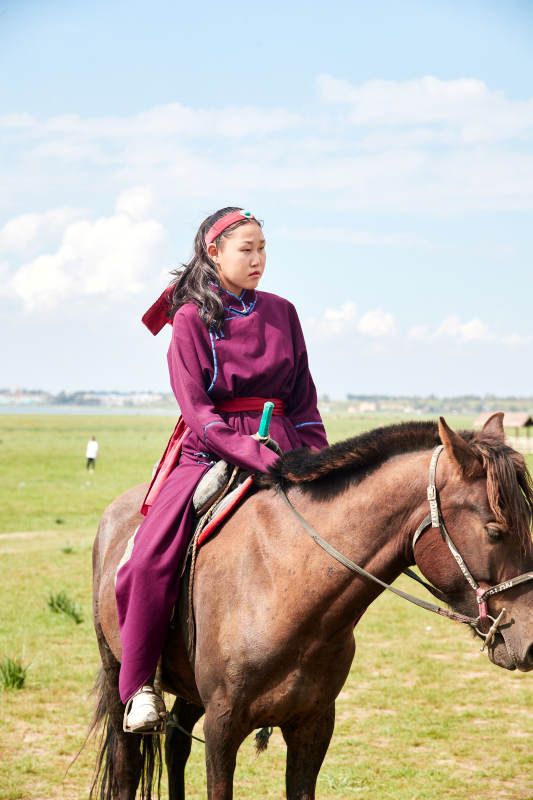 草原那达慕大会上骑着马的蒙古姑娘图片
