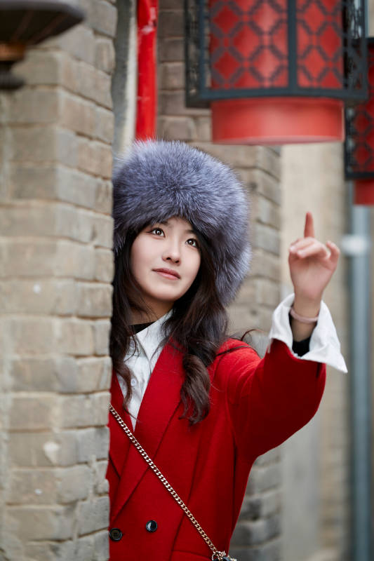 春节在老城古巷穿着喜庆服饰的美丽少女图片