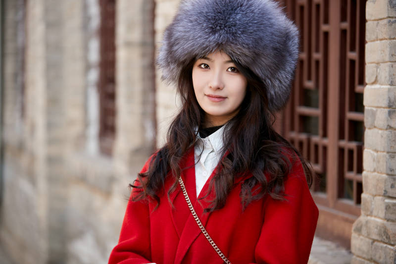 春节在老城古巷穿着喜庆服饰的美丽少女图片