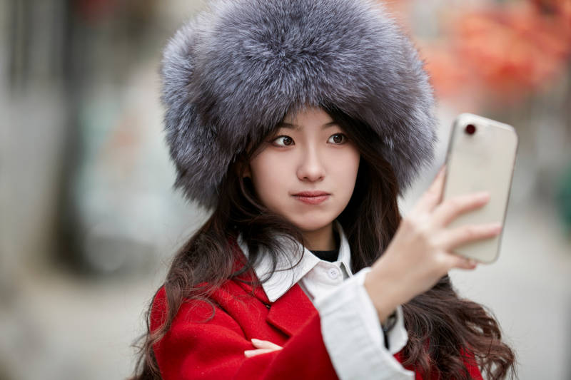 春节在老城古巷穿着喜庆服饰的美丽少女图片