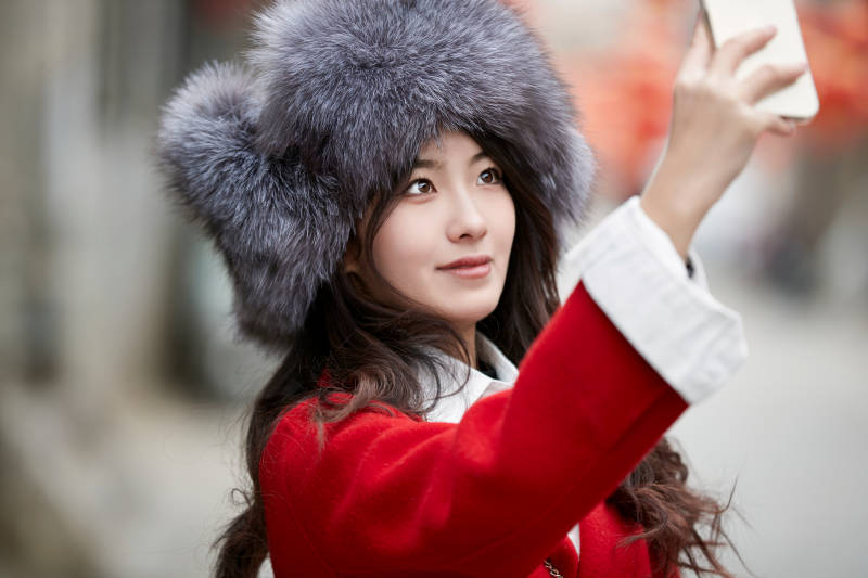 春节在老城古巷穿着喜庆服饰的美丽少女图片