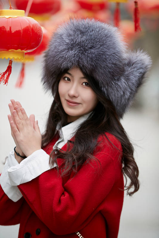 春节在老城古巷穿着喜庆服饰的美丽少女图片