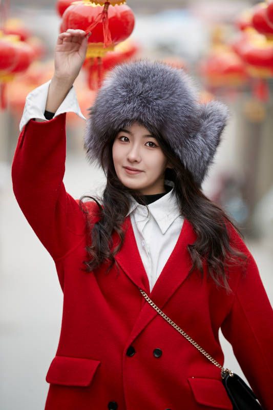 春节在老城古巷穿着喜庆服饰的美丽少女图片