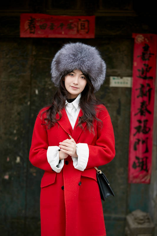 春节在老城古巷穿着喜庆服饰的美丽少女图片