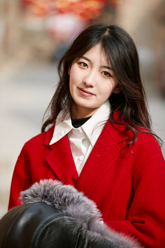 春节在老城古巷穿着喜庆服饰的美丽少女图片