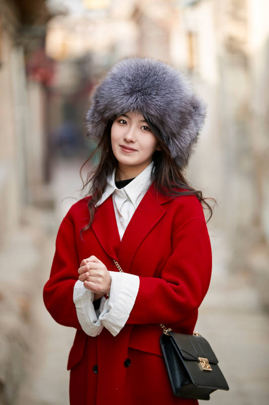 春节在老城古巷穿着喜庆服饰的美丽少女图片