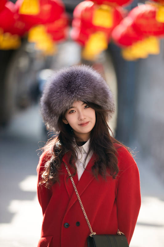 春节在老城古巷穿着喜庆服饰的美丽少女图片