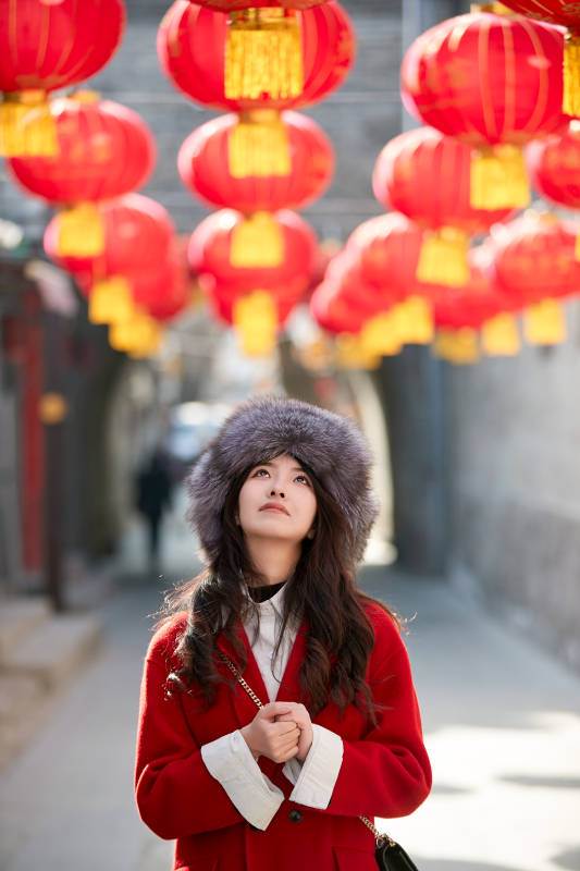 春节在老城古巷穿着喜庆服饰的美丽少女图片