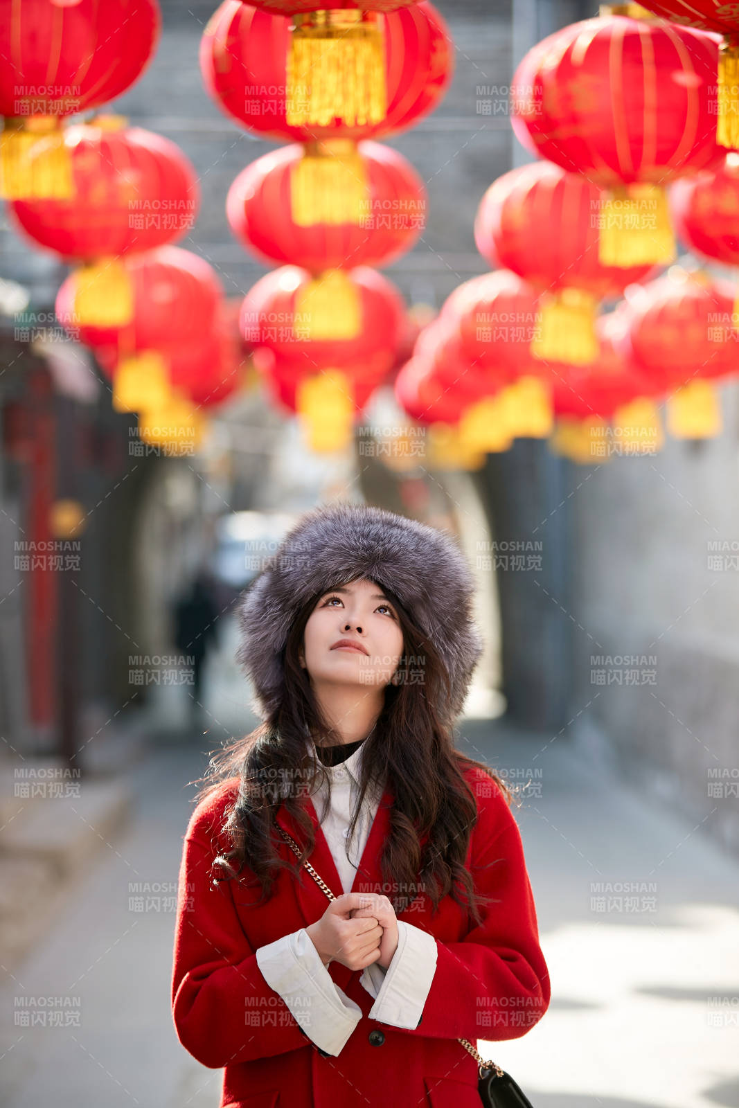 春节在老城古巷穿着喜庆服饰的美丽少女图片