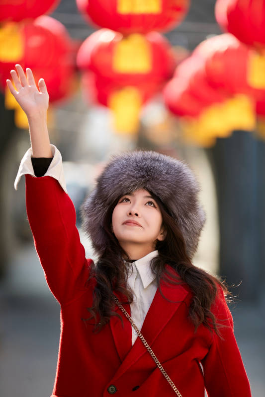 春节在老城古巷穿着喜庆服饰的美丽少女图片