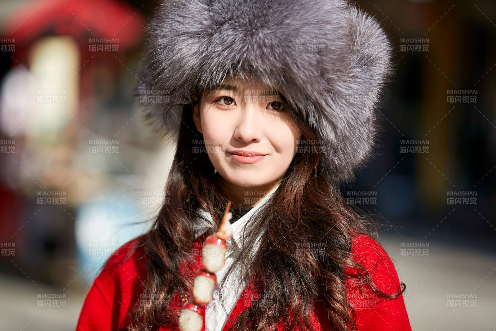 穿着喜庆服饰吃糖葫芦的美丽少女图片