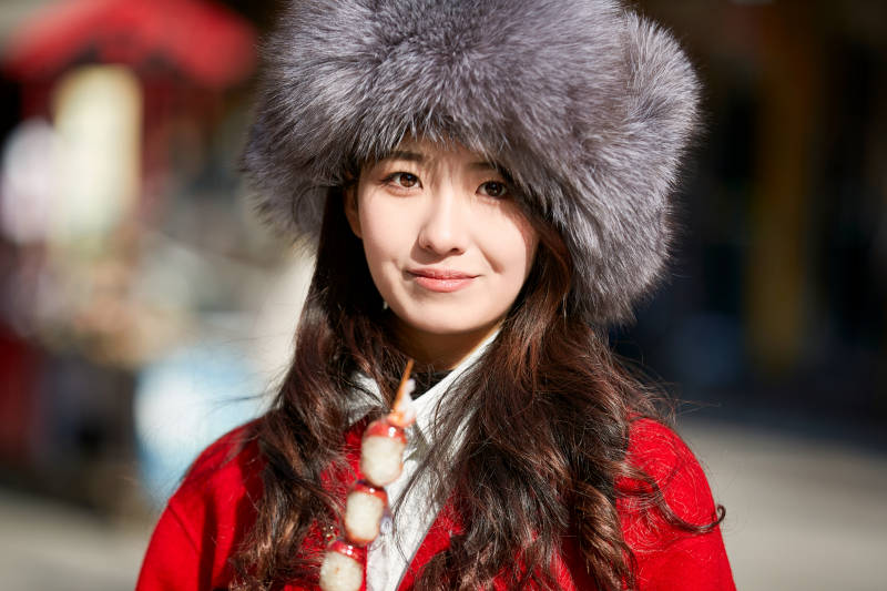 穿着喜庆服饰吃糖葫芦的美丽少女图片