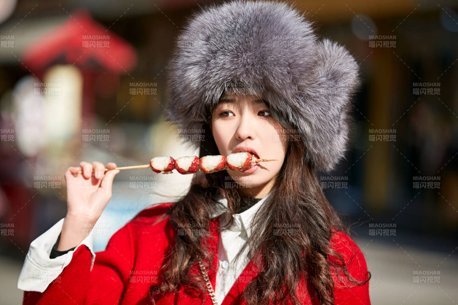 穿着喜庆服饰吃糖葫芦的美丽少女图片