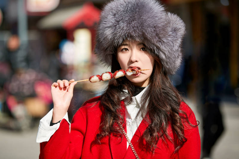 穿着喜庆服饰吃糖葫芦的美丽少女图片