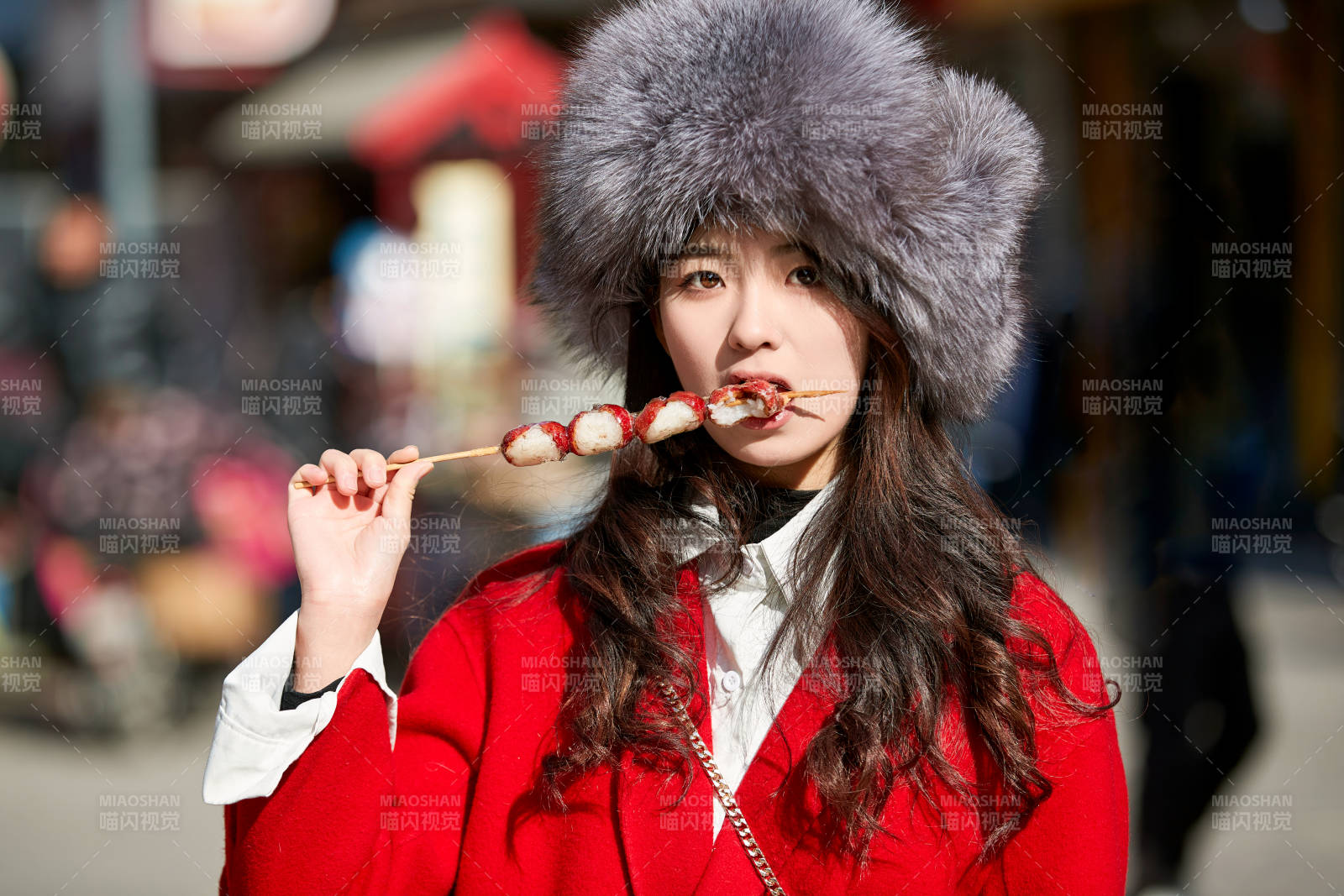 穿着喜庆服饰吃糖葫芦的美丽少女图片