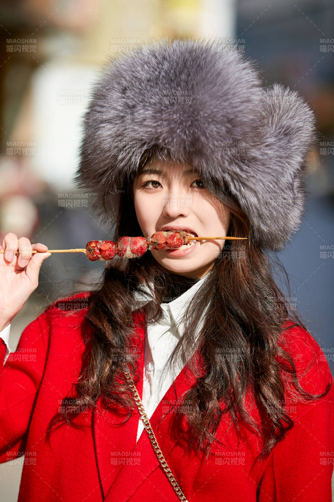 穿着喜庆服饰吃糖葫芦的美丽少女图片