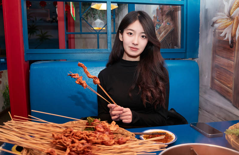 在饭馆吃成都串串的亚洲少女图片