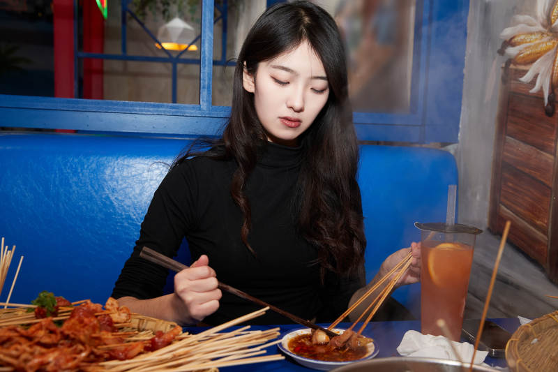 在饭馆吃成都串串的亚洲少女图片