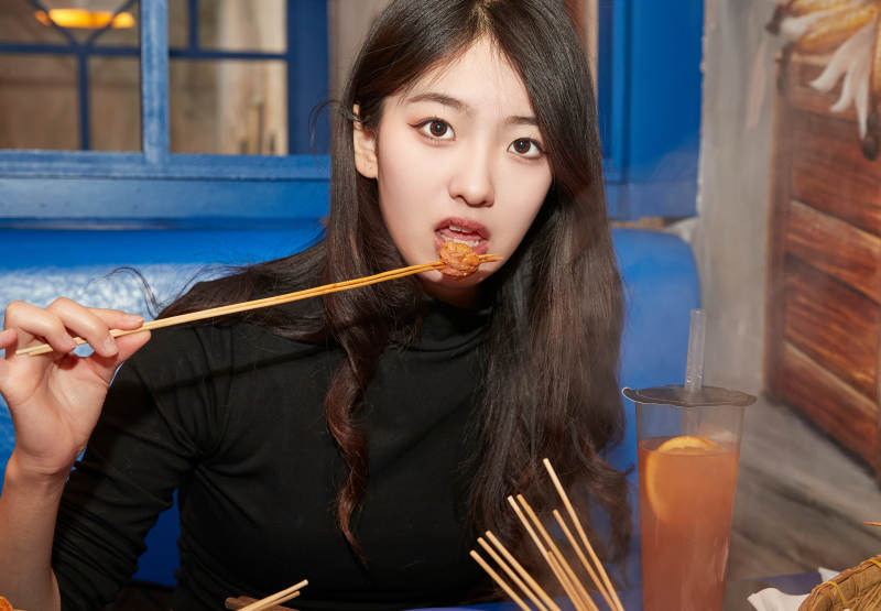 在饭馆吃成都串串的亚洲少女图片