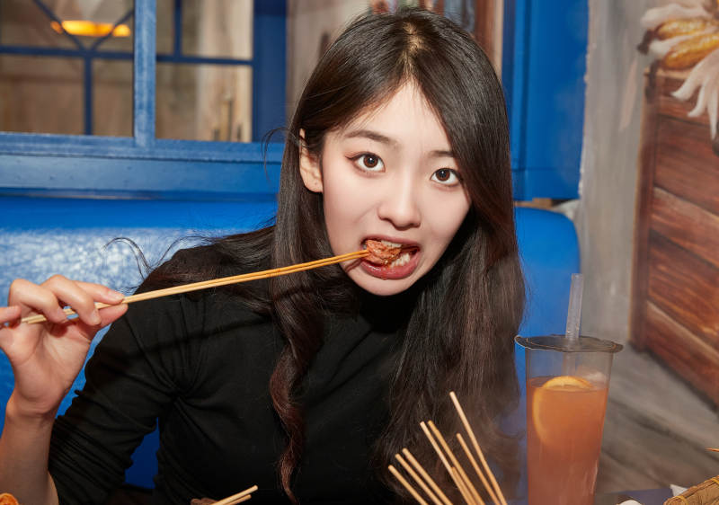 在饭馆吃成都串串的亚洲少女图片