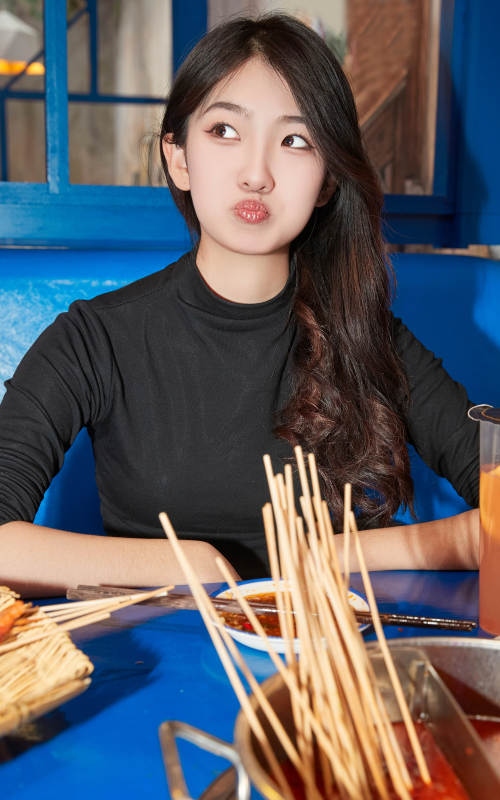 在饭馆吃成都串串的亚洲少女图片