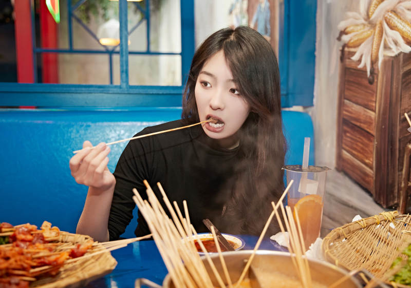 在饭馆吃成都串串的亚洲少女图片