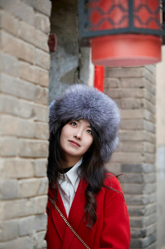 春节在老城古巷穿着喜庆服饰的美丽少女图片