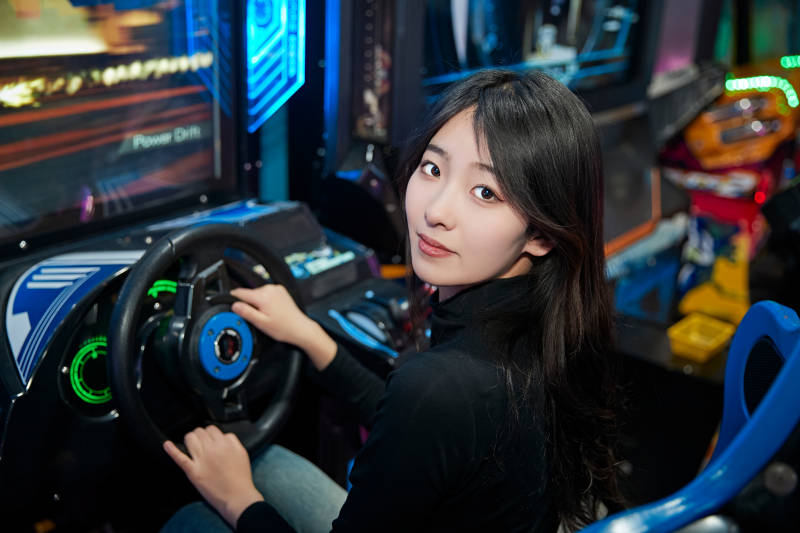 在电子游戏娱乐城玩耍的时尚少女图片