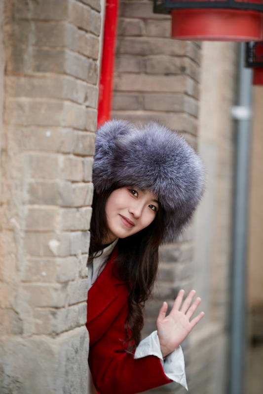 春节在老城古巷穿着喜庆服饰的美丽少女图片