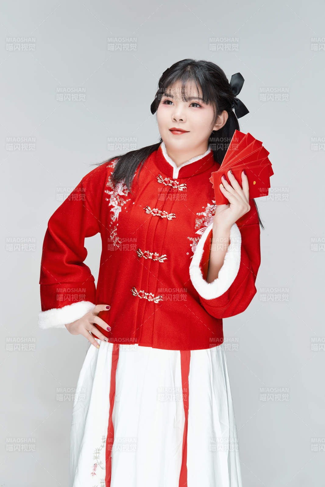 白色背景下身穿喜庆汉服手拿红包的可爱少女图片