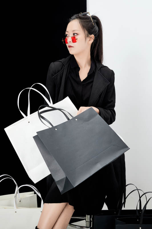 黑白色背景下的手提购物袋的时尚亚洲少女图片