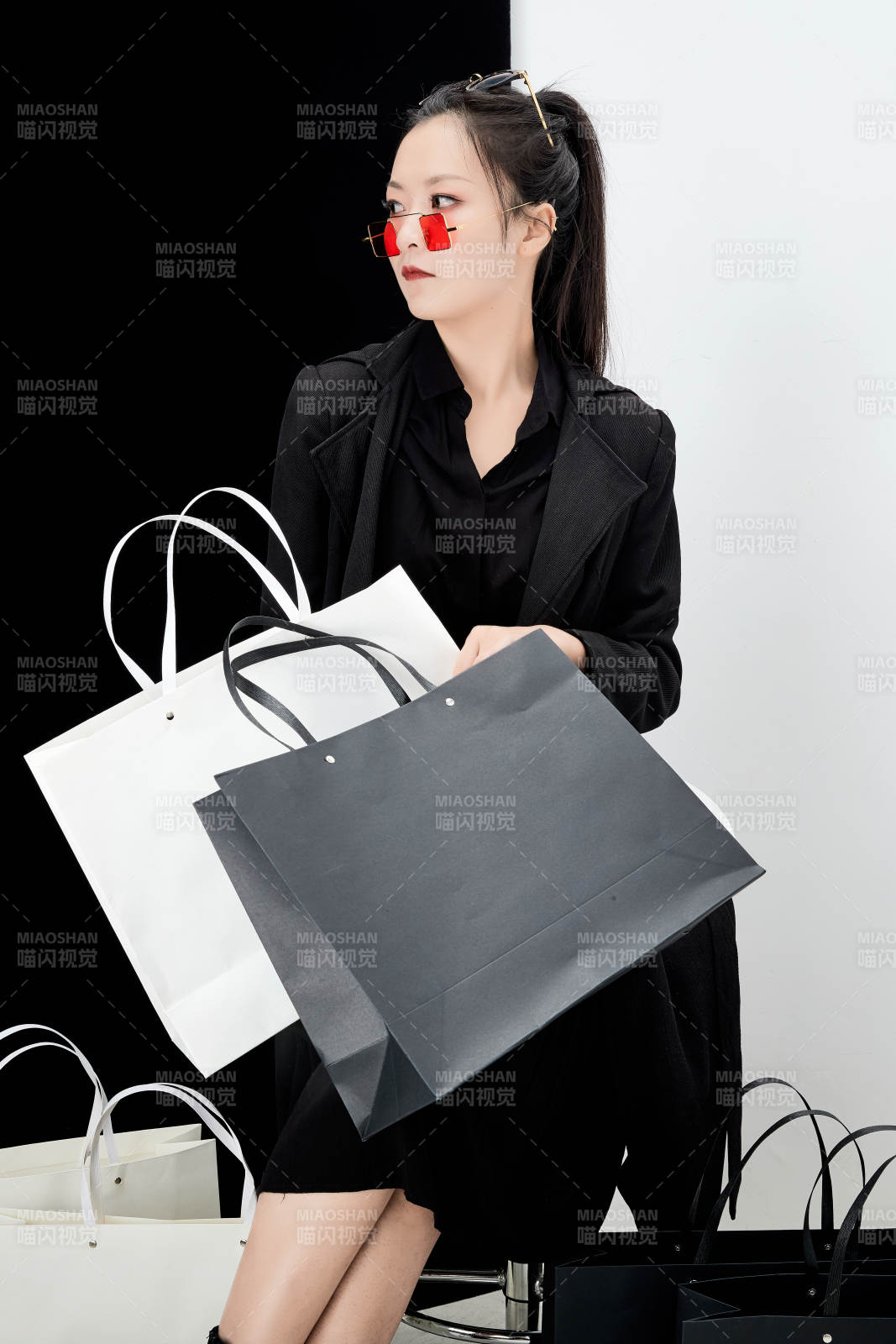 黑白色背景下的手提购物袋的时尚亚洲少女图片