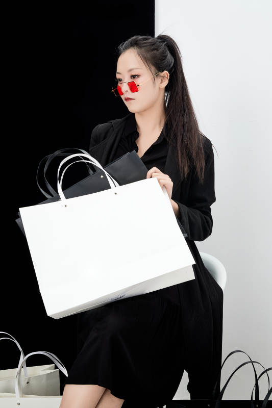 黑白色背景下的手提购物袋的时尚亚洲少女图片