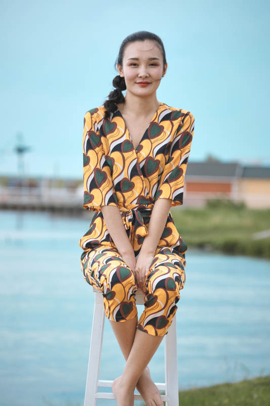 悠闲的坐在美丽湖岸码头的亚洲年轻女性人像图片