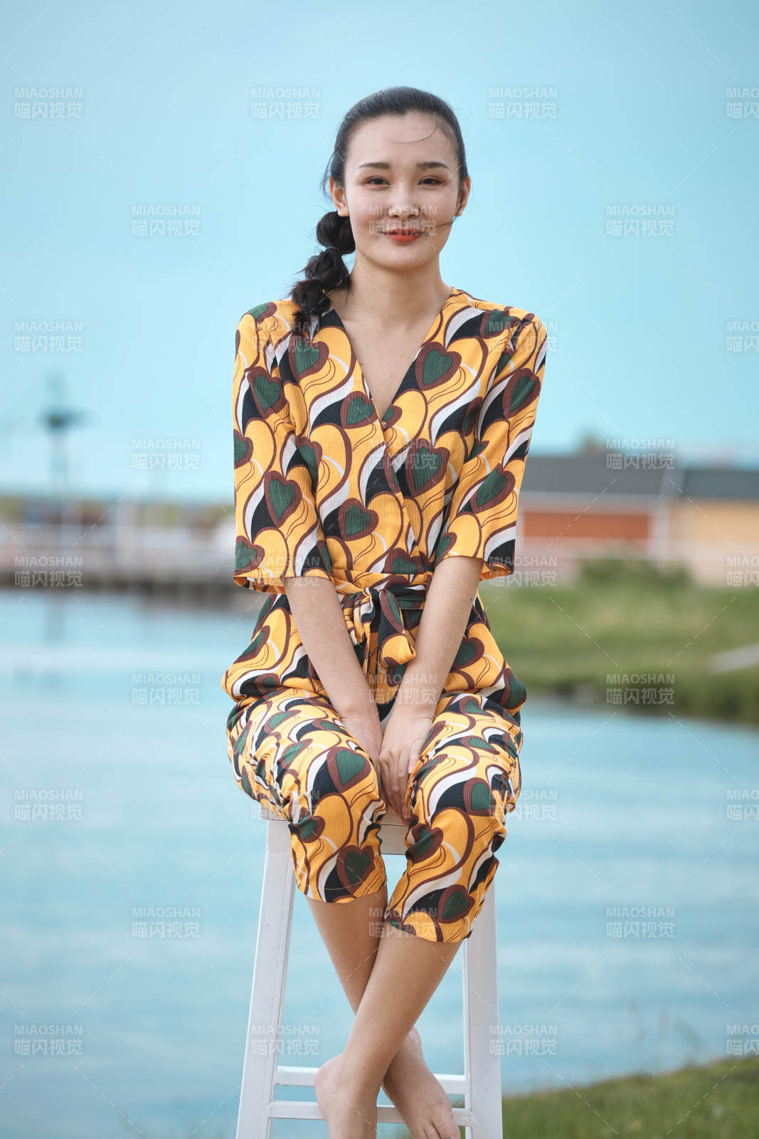 悠闲的坐在美丽湖岸码头的亚洲年轻女性人像图片