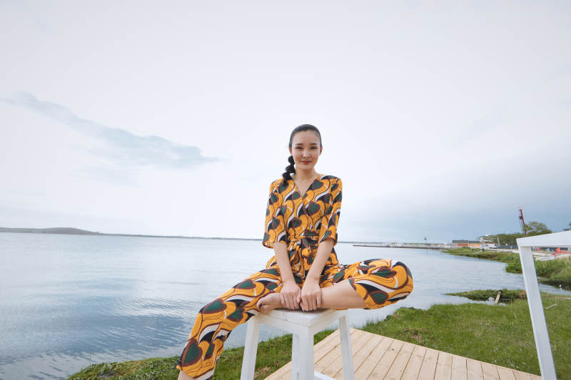 悠闲的坐在美丽湖岸码头的亚洲年轻女性人像图片