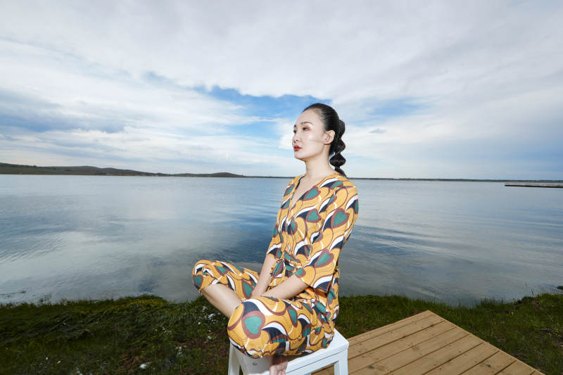 悠闲的坐在美丽湖岸码头的亚洲年轻女性人像图片